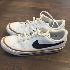 Nike White Low-Top Sneakers with Black Swoosh and Gold Accent